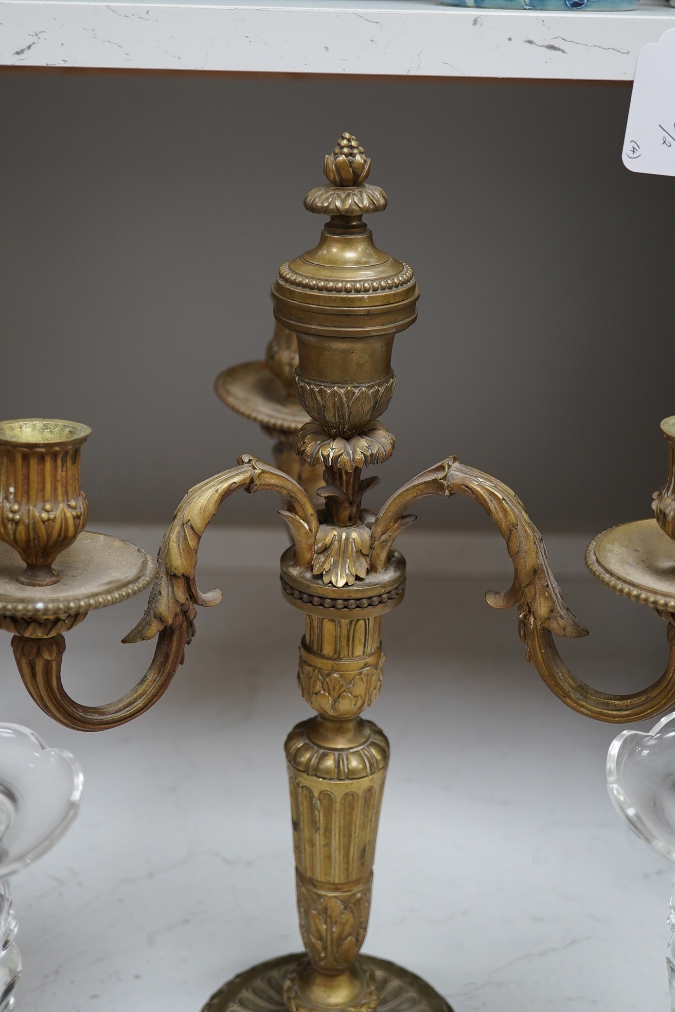 Two pairs of cut glass candlesticks and a gilt metal three branch candelabra, largest 44cm high. Condition - fair, some minor chipping